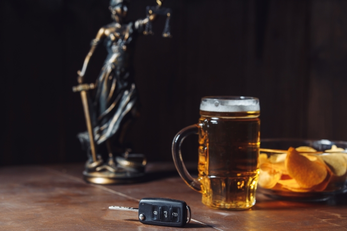 Lady of justice, glass of beer and car key See less